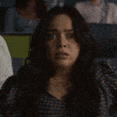 a woman is making a surprised face while sitting in a classroom .
