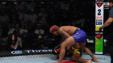 two men are wrestling in a ring with a sign that says 2 shots in every can