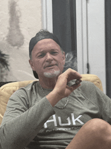 a man is smoking a cigar and wearing a shirt that says huk