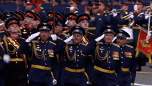 a group of men in military uniforms salute with the letter u on their hats