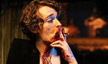 a person with blood on their face smoking a cigarette