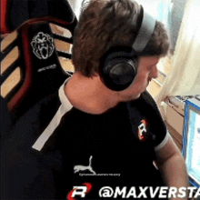 a man wearing headphones is sitting in front of a computer screen that says @maxversta on it