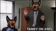 a man in a suit and tie is standing next to two dogs with red eyes and the words tabby on xrpl above them