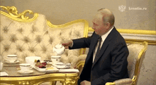 a man sits at a table with a kremlin.ru logo on the bottom