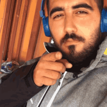 a man with a beard wearing headphones and a jacket that says ' abercrombie & fitch ' on it