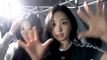 a girl wearing an adidas shirt is making a face