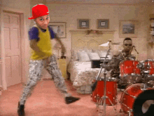 a man in a red hat is dancing in a bedroom