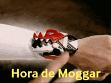 a person wearing a watch that says hora de moggar on the bottom