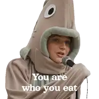 a person in a fish costume singing into a microphone with the words you are who you eat