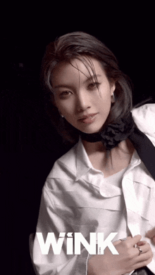 a woman is wearing a white shirt and a black tie with the word wink on the bottom