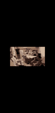 a group of people are gathered in a living room with a box on the floor