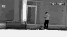 a man talking on a cell phone in front of a building with #gitcontrol on the bottom