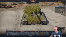 a man is playing a video game with a tank in the background and a red button that says schlacht