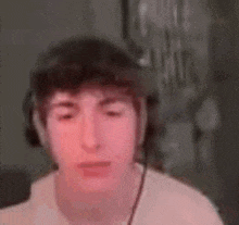 a young man wearing headphones and a hat is making a funny face .