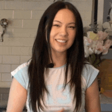 a woman wearing a shirt with the number 13 on it smiles