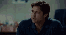 a man in a blue shirt says what in a blurry photo