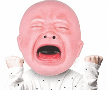 a baby wearing a pink crying mask with his mouth open and his fist in the air .