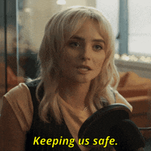 a woman speaking into a microphone with the words keeping us safe on the bottom