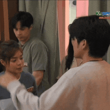 a man in a white shirt is talking to a woman in a blue shirt with a sticker that says pw