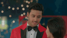 a man in a red suit and a woman in a red dress are dancing together