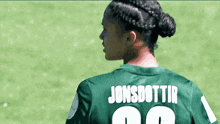 a woman in a green jersey with the name jonsdottir on the back