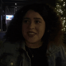 a woman with curly hair is smiling with the word yeah behind her