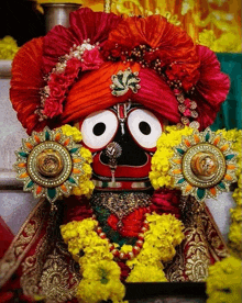 a close up of a statue of a deity with flowers around his face