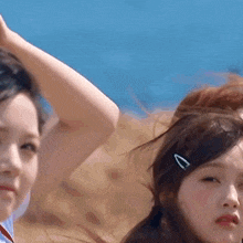 two women are standing next to each other with their hair in a ponytail .