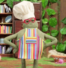 a stuffed frog wearing a chef 's hat and apron stands with his hands on his hips .