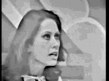 a black and white photo of a woman with long hair and a bow tie .