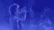 a person singing into a microphone with a star on the back of their shirt