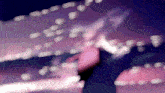 a blurry picture of a person 's face and a purple background with a few white dots