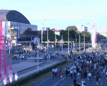 a crowd of people walking down a street in front of a building