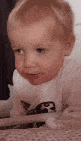 a baby is wearing a white shirt with a leopard print