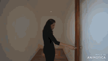 a woman is opening a door with the words made in animatica on the bottom