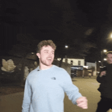a man wearing a light blue north face sweatshirt