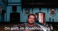 a man sitting in a church with the words " on gurt im dreadhogging it " above him