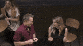 a man and a woman are sitting at a table talking