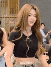 a woman wearing a black crop top with the word wavchan on the bottom