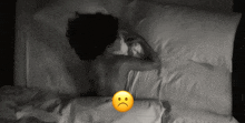 a woman laying on a bed with a sad face on the bottom