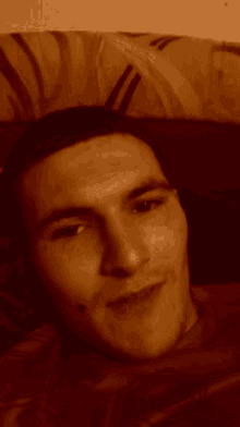 a man laying on a bed with a clock behind him
