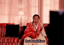 a woman is sitting on a couch with the words hai band karo written on it