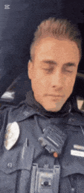 a police officer with his eyes closed and a walkie talkie on his chest