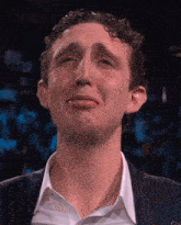 a man in a suit and white shirt is crying with tears running down his face