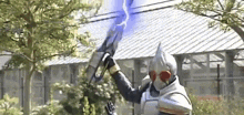 a man in a knight 's armor is holding a sword with a lightning bolt coming from it .