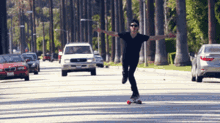 a man is riding a skateboard down a street with cars driving by