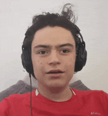 a young man wearing headphones and a red shirt that says atoo