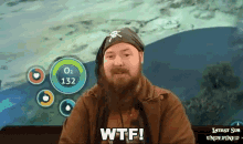 a man with a beard is saying wtf in front of a screen