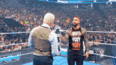 two men are standing in a wrestling ring and one of them is wearing a shirt that says " never meet again " .