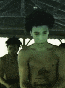 a man without a shirt is looking at something